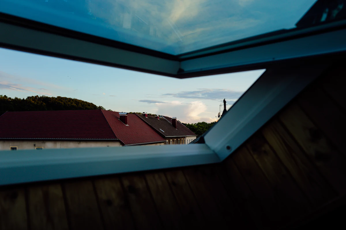 Red-roofed houses seen through an open roof window